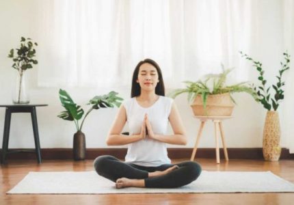 Asian woman doing yoga meditation at home